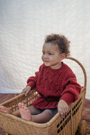 The red pom-pom knit sweater