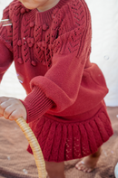 The red pom-pom knit sweater
